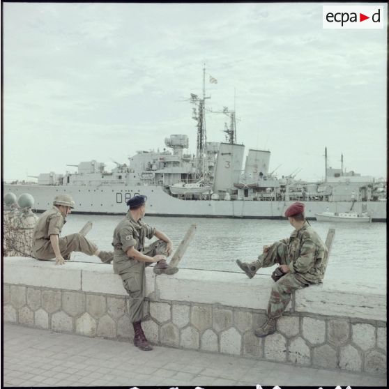 Trois permissionnaires français contemplent le destroyer "HMS Barfleur" à Port-Saïd.