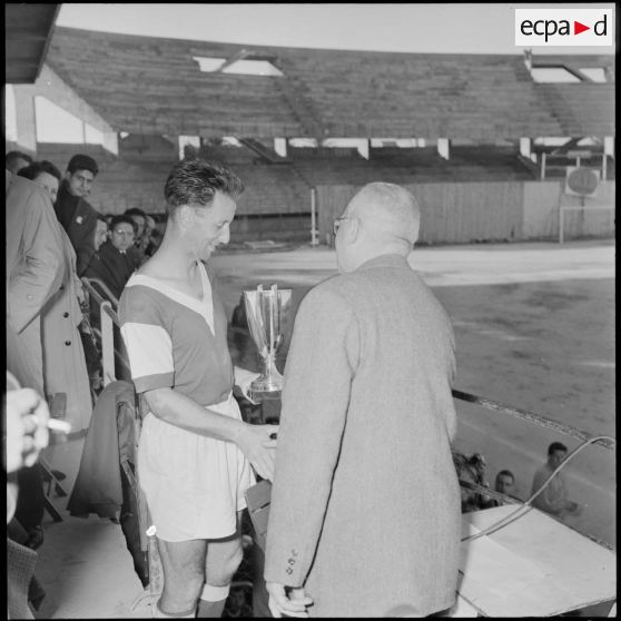 M. Lecanelier remet la coupe au capitaine de l'équipe de Reims.