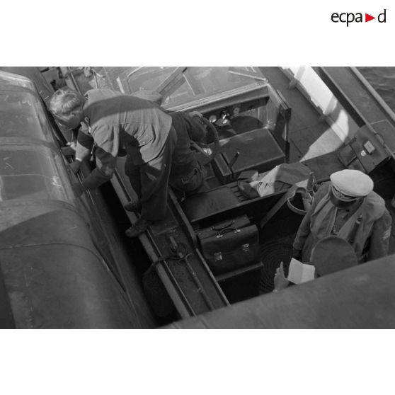 Des aviateurs allemands, dont un Oberstleutnant et des officiers de la Heer, discutent dans une vedette, à côté d'un hydravion B&V-138 du See-Aufklaerungsgruppe-125.