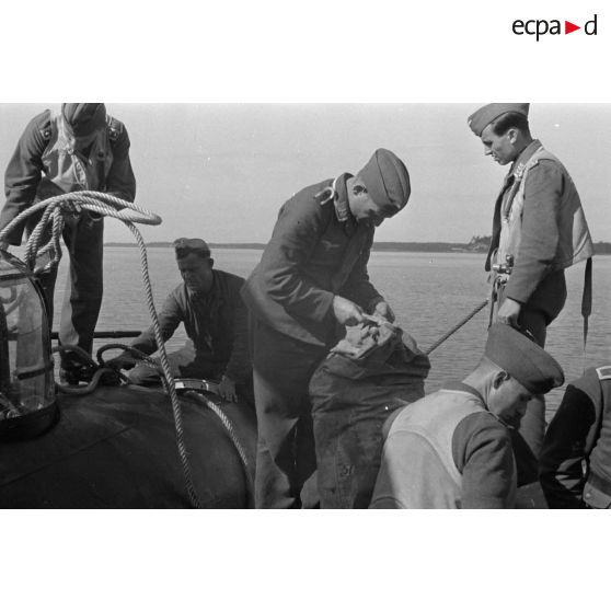 Amarrage d'un B&V-138 et déchargement de sacs par des aviateurs allemands, sous le regard des pilotes.