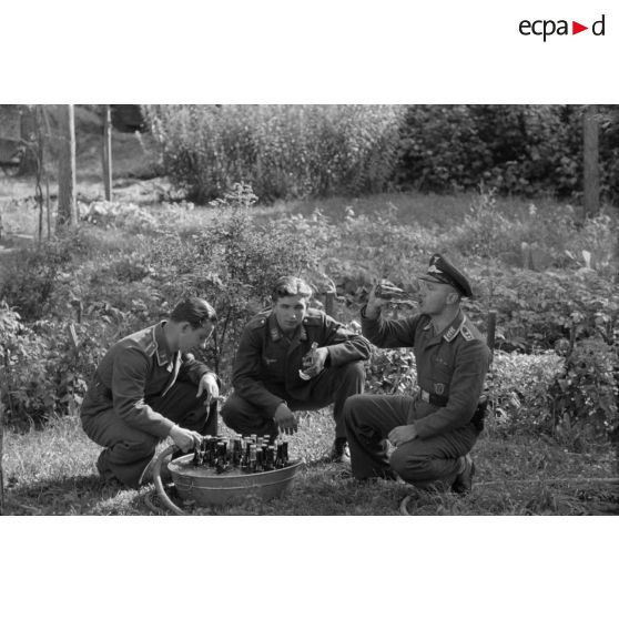 Un Oberfeldwebel du See-Aufklaerungsgruppe-125 et deux aviateurs allemands boivent de la bière.