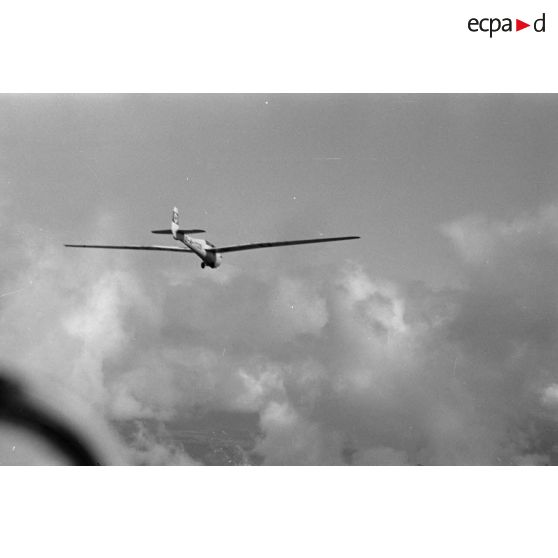 Un planeur biplace de type DFS Habicht du N.S.F.K (Nationalistischen Flieger-Korps) en vol au milieu des nuages.