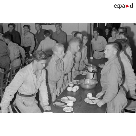 Jeunes membres du N.S.F.K. se levant de table lors d'un repas.