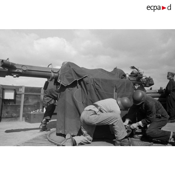 Différentes phases du débâchage d'un télémètre Kommandogeraet-36, par trois de ses servants.