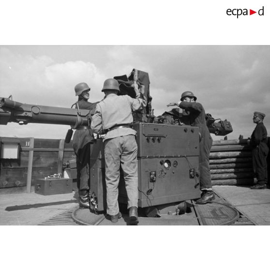 Différentes phases du débâchage d'un télémètre Kommandogeraet-36, par trois de ses servants.