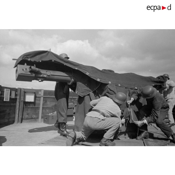 Différentes phases du débâchage d'un télémètre Kommandogeraet-36, par trois de ses servants.