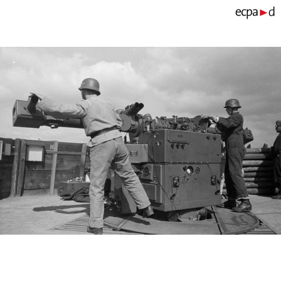 Différentes phases du débâchage d'un télémètre Kommandogeraet-36, par trois de ses servants.