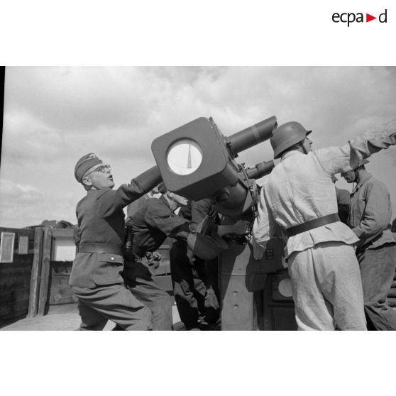 Mise en position d'un télémètre Kommandogerät-36 par ses servants, sous la direction d'un Leutnant.