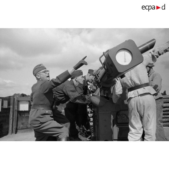 Mise en position d'un télémètre Kommandogerät-36 par ses servants, sous la direction d'un Leutnant.