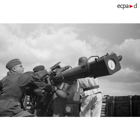 Mise en position d'un télémètre Kommandogerät-36 par ses servants, sous la direction d'un Leutnant.