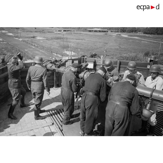 Mise en position d'un télémètre Kommandogerät-36 par ses servants, sous la direction d'un Leutnant.