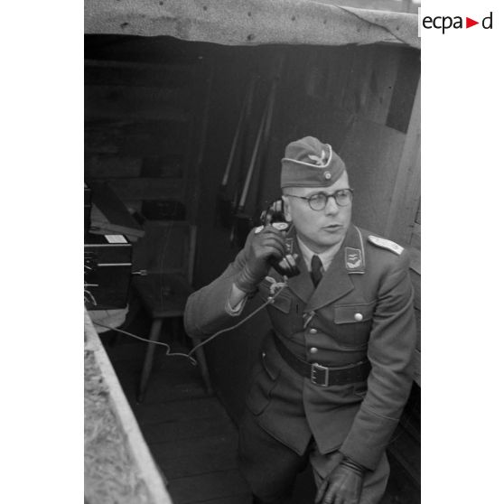 Un lieutenant de la DCA de l'armée de l'air (Oberleutnant de la FlaK), dans un abri, parle au téléphone.