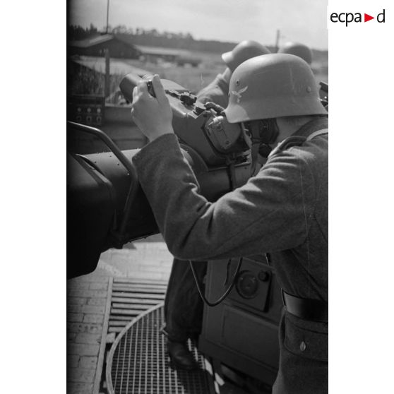 Un observateur de la FlaK, de dos, à son poste de télémétrie sur un Kommandogerät-36.