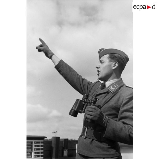 Un Leutnant de la DCA de l'armée de l'air allemand (FlaK) donne des indications de direction à des servants de télémètre.