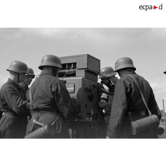 Des servants d'un télémètre de soutien, Kommandohilfsgeraet-35, au travail, sous la direction d'un Leutnant.