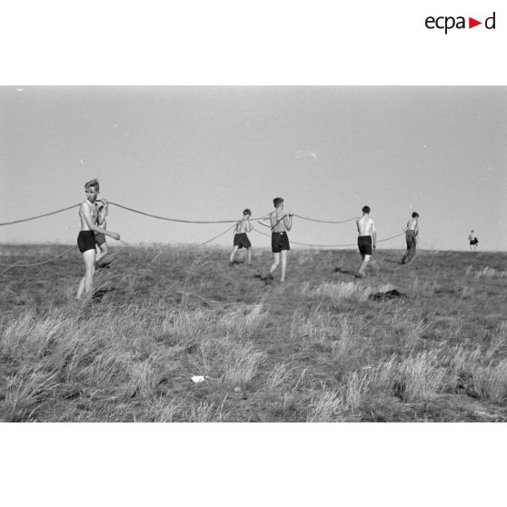 Des jeunes membres du Nationalsozialistischen Flieger-Korps (N.S.F.K.) tirent la corde destinée à donner la vitesse nécessaire au décollage d'un planeur léger.
