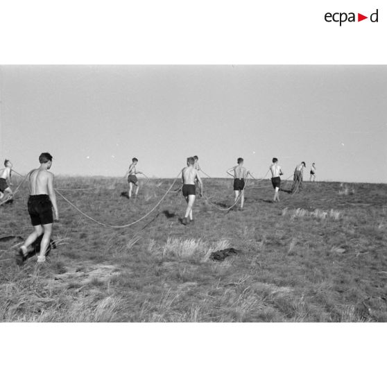Des jeunes membres du Nationalsozialistischen Flieger-Korps (N.S.F.K.) tirent la corde destinée à donner la vitesse nécessaire au décollage d'un planeur léger.