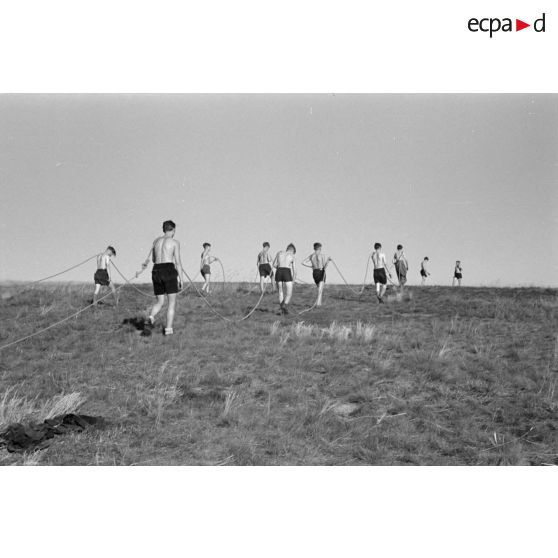 Des jeunes membres du Nationalsozialistischen Flieger-Korps (N.S.F.K.) tirent la corde destinée à donner la vitesse nécessaire au décollage d'un planeur léger.