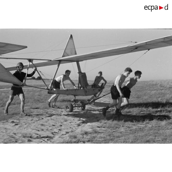De jeunes membres du Nationalsozialistischen Flieger-Korps (N.S.F.K.) acheminent un planeur léger Schulgleiter Sg 38 sur son aire d'envol.