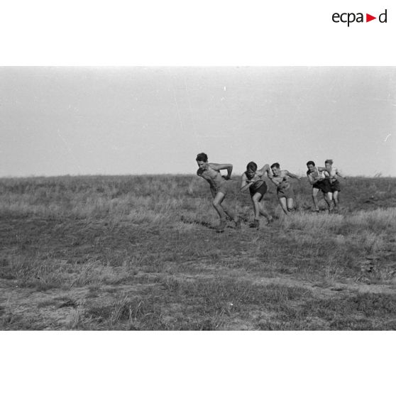 Des jeunes du Nationalsozialistischen Flieger-Korps (N.S.F.K.) courent en tirant une corde afin de donner sa vitesse ascensionnelle à un planeur léger.
