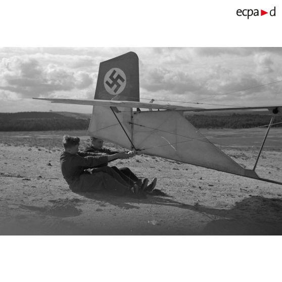 Deux jeunes du Nationalsozialistischen Flieger-Korps (N.S.F.K.) retiennent l'empennage d'un planeur avant le décollage.