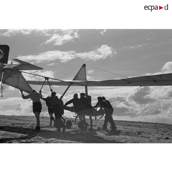Des jeunes membres du Nationalsozialistischen Flieger-Korps (N.S.F.K.) acheminent un planeur léger sur son aire d'envol.