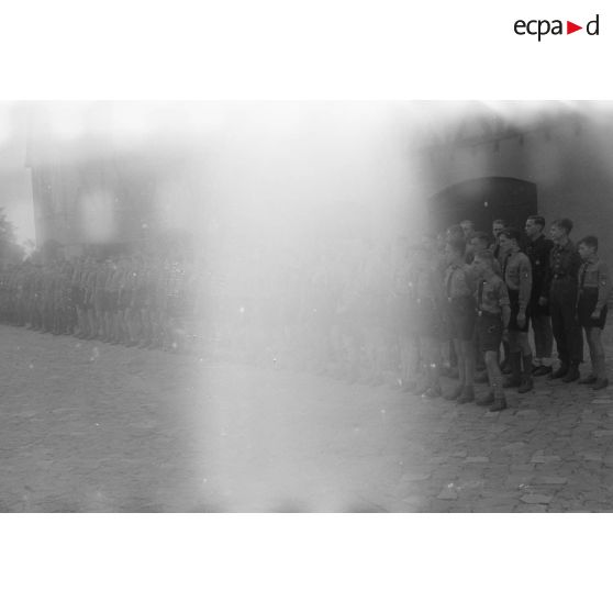 Deux officiers supérieurs du NSFK, le Gruppenführer Dr. Otto Zimmermann et un Hauptsturmführer passent en revue des jeunes, au garde-à-vous (image altérée).
