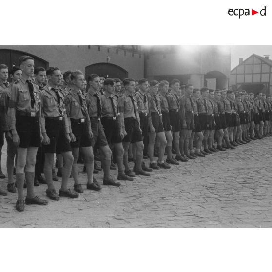 Alignement de jeunes membres du N.S.F.K., en tenue d'été, lors d'une cérémonie.