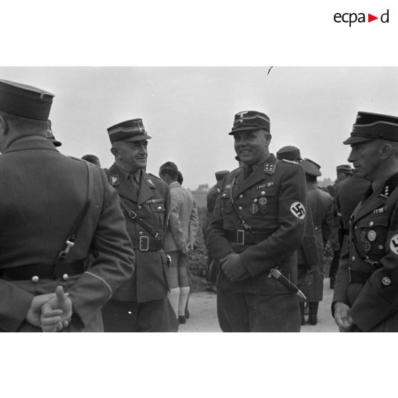 Groupe de dignitaires du N.S.F.K. en discussion dont un Sturmbannführer et un Brigadeführer.
