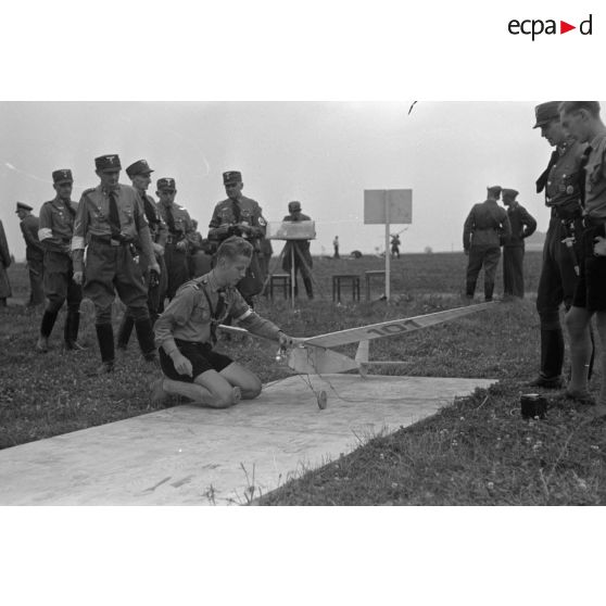 Un membre des Hitlerjugend prépare un modèle réduit d'avion avant son décollage.