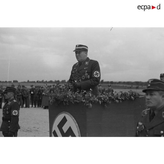 L'Obergruppenführer Karl Sauke du N.S.F.K. debout derrière une tribune, prononce un discours.