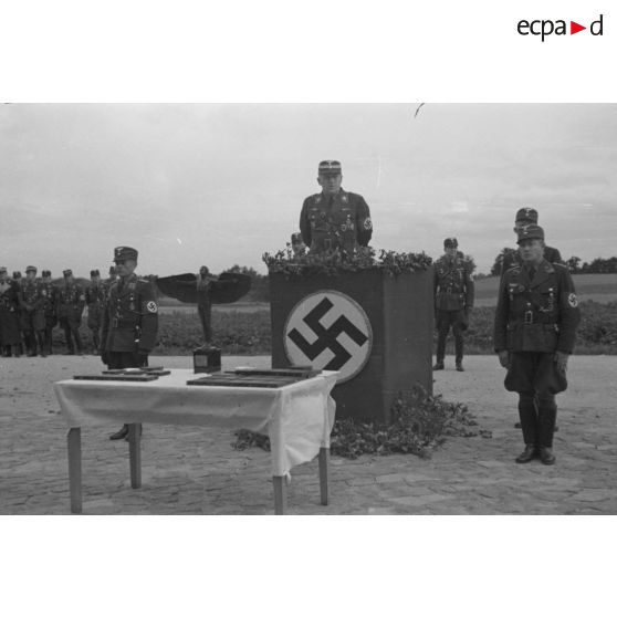 L'Obergruppenführer Karl Sauke du N.S.F.K. debout derrière une tribune, prononce un discours.
