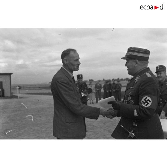 Le NSFK-Gruppenführer Karl Sauke remet un prix à un homme portant des vétements civils.