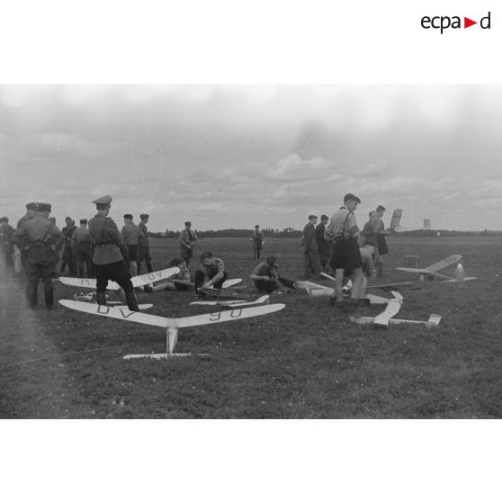 Membres de la Hitlerjugend et civils au milieu de modèles réduits d'avions.