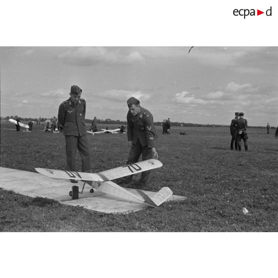 Deux aviateurs allemands regardent le modèle réduit d'avion d'un membre de la Hitlerjugend.