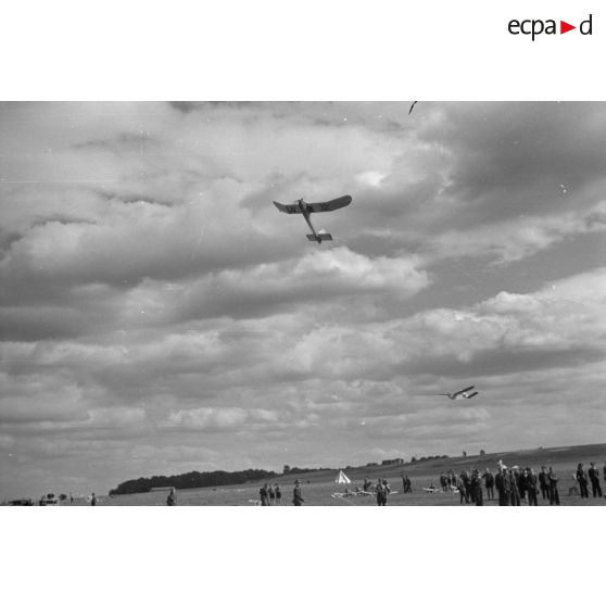 Un modèle réduit d'avion décolle, tractant un modèle réduit de planeur.