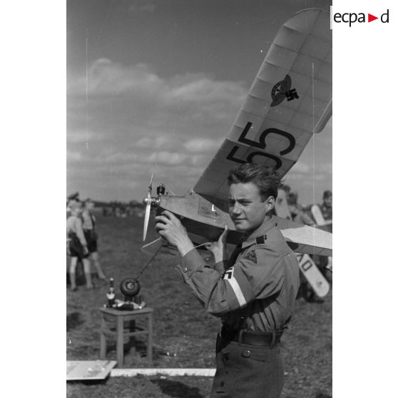 Un membre de la Hitlerjugend appartenant au district "Westfalen" s'apprète à faire décoller son modèle réduit d'avion.
