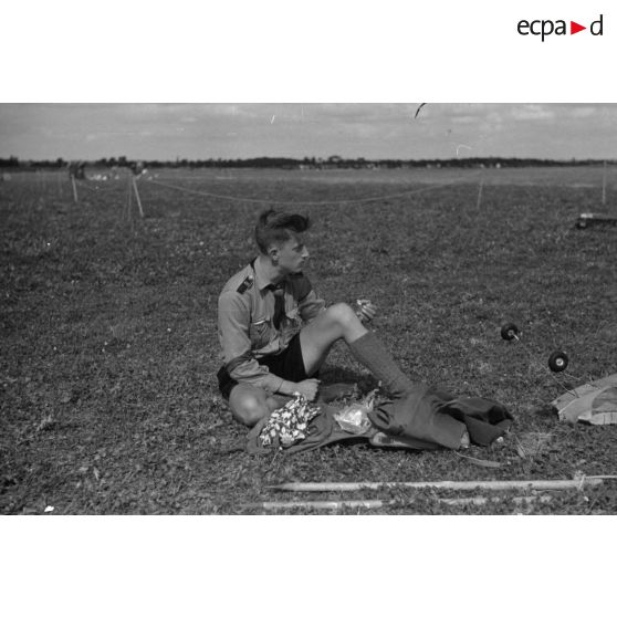 31. Un membre de la Hitlerjugend se restaure assis sur l'herbe.