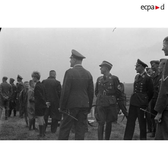 Des membres du N.S.F.K. et de la Luftwaffe assistent à un concours de modèles réduits d'avions.