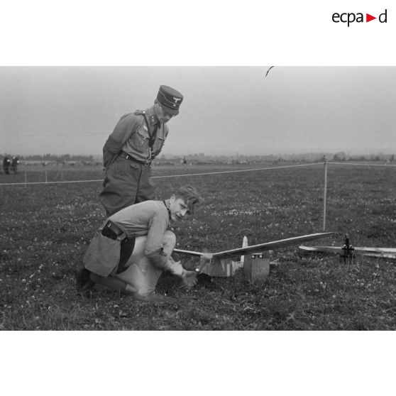 Un membre de la Hitlerjugend s'apprète à faire décoller son modèle réduit, sous le regard d'un membre du Nationalistischen Flieger-Korps (NSFK).