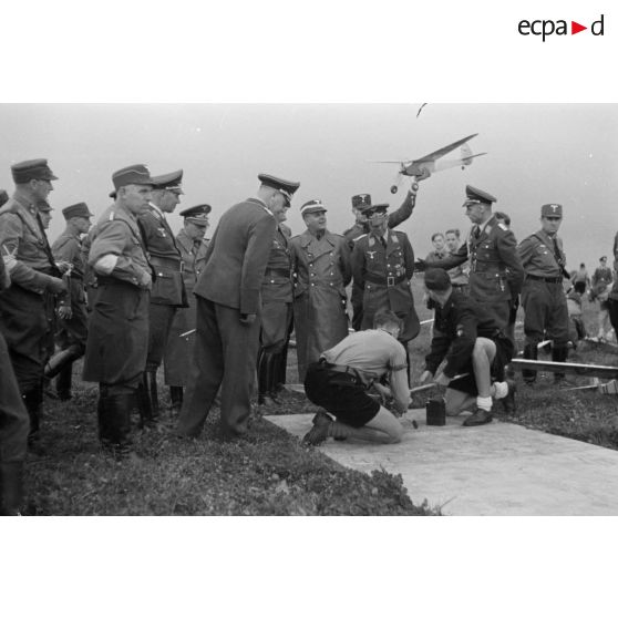 Un foule composée de civils, de membres de la Luftwaffe et du N.S.F.K. assistent au décollage et aux évolutions des modèles réduits lancés par des membres de la Hitlerjugend.