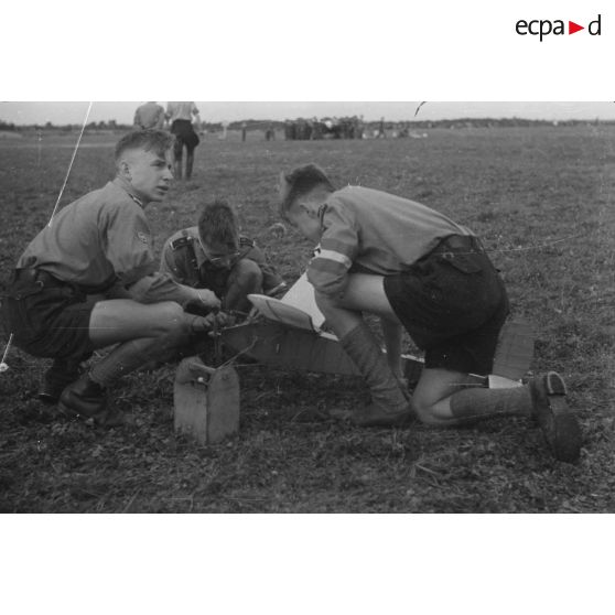 Trois membres de la Hitlerjugend s'apprètent à faire décoller leur modèle réduit.