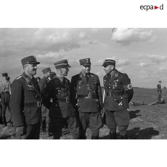 Quatre membres du N.S.F.K. discutent durant les épreuves des modèles réduits (Reichswettkampf der Modellfluggruppen der Hitler-Jugend)