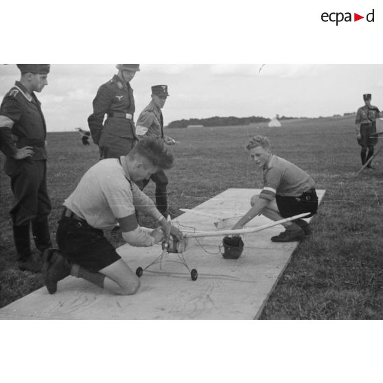 Deux membres de la Hitlerjugend s'apprètent à faire décoller un modèle réduit d'avion remorquant un modèle réduit