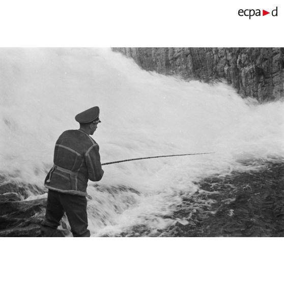 Des officiers de la Luftwaffe pèchent dans un cours d'eau montagneux en Finlande.