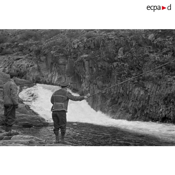 Des officiers de la Luftwaffe pèchent dans un cours d'eau montagneux en Finlande.
