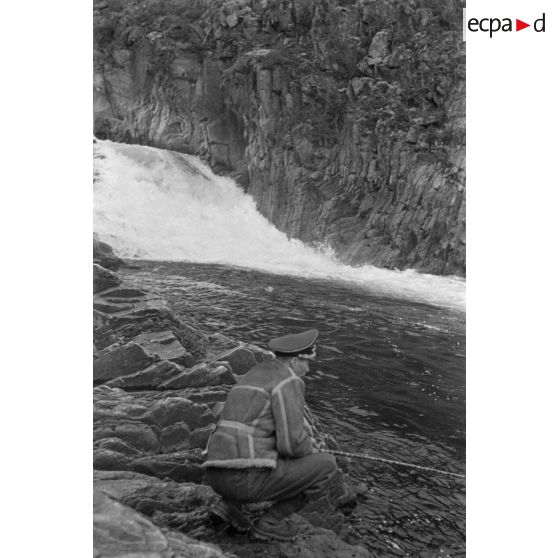 Des officiers de la Luftwaffe pèchent dans un cours d'eau montagneux en Finlande.