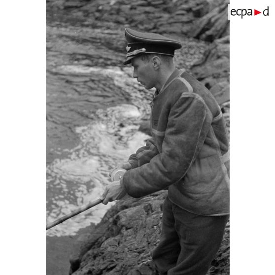 Des officiers de la Luftwaffe pèchent dans un cours d'eau montagneux en Finlande.