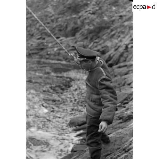 Des officiers de la Luftwaffe pèchent dans un cours d'eau montagneux en Finlande.