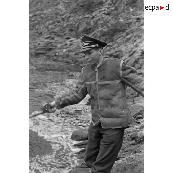 Des officiers de la Luftwaffe pèchent dans un cours d'eau montagneux en Finlande.